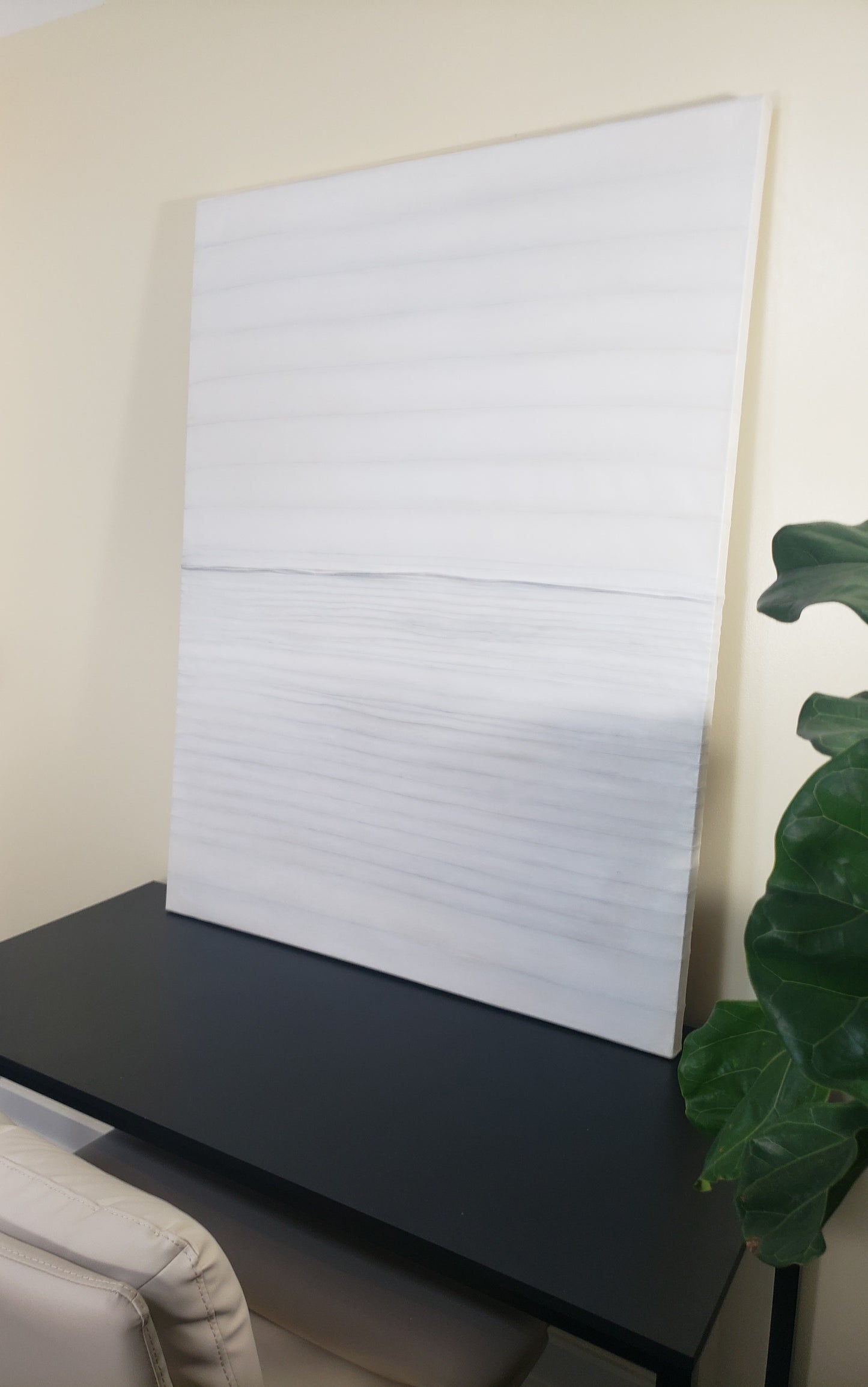 Stitched Horizon 01 painting by Carrie Bergey leaning on a black desk, emphasizing its soft stitched textures and minimalist mixed media design.