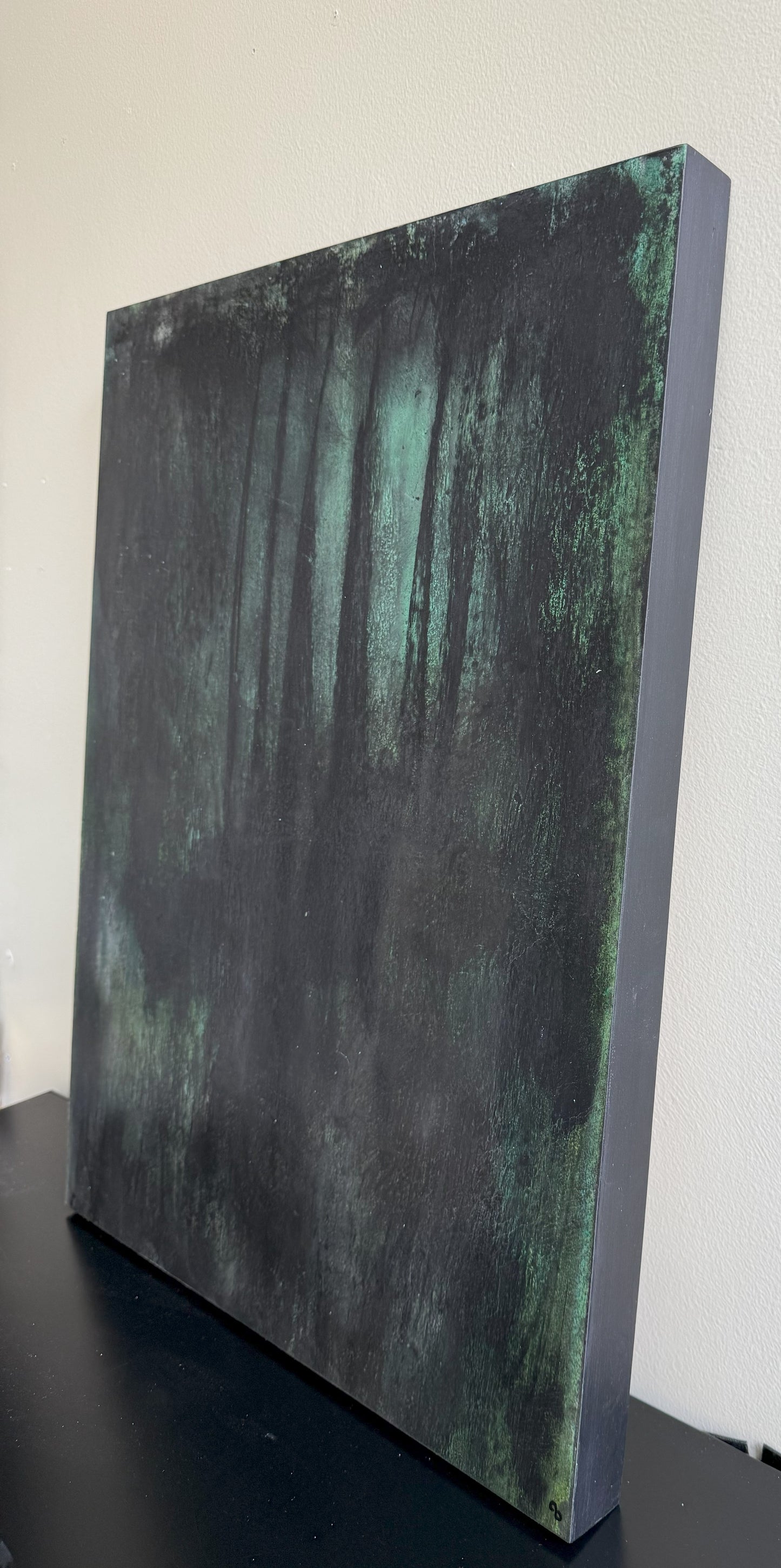 Side view of 'Through' by Carrie Bergey on gallery-wrapped canvas. Original abstract art with dark green hues and forest silhouettes.