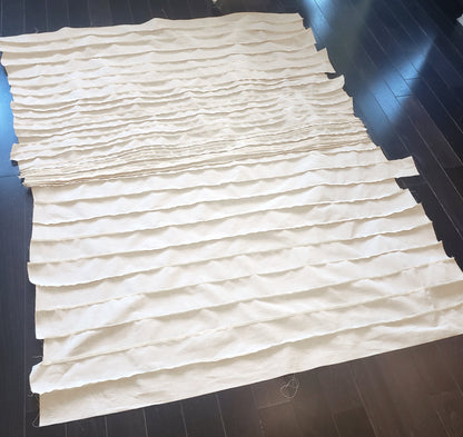 Unassembled textile layers for Stitched Horizon 01 by Carrie Bergey laid out on a dark floor, highlighting the handcrafted process behind the mixed media piece.